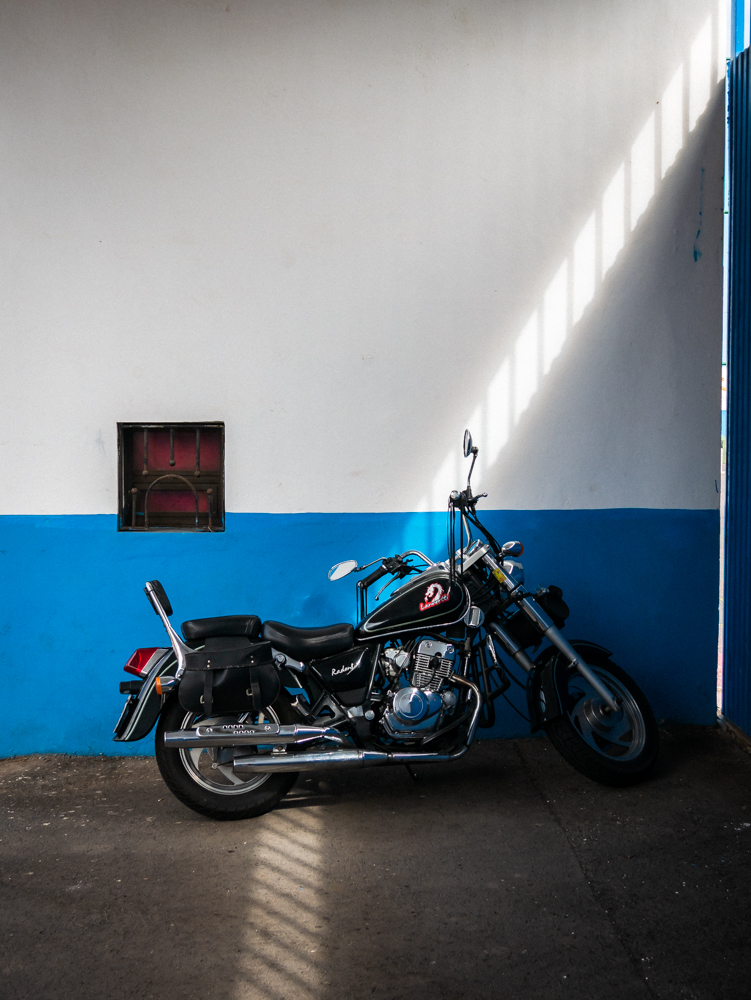 Moto garés devant un mur bleu et blanc à Ténérife