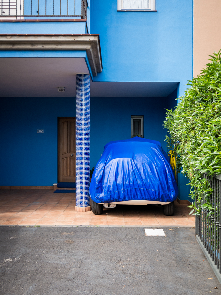Voitures sous une bache bleu devant un mur de même couleur à Ténérife