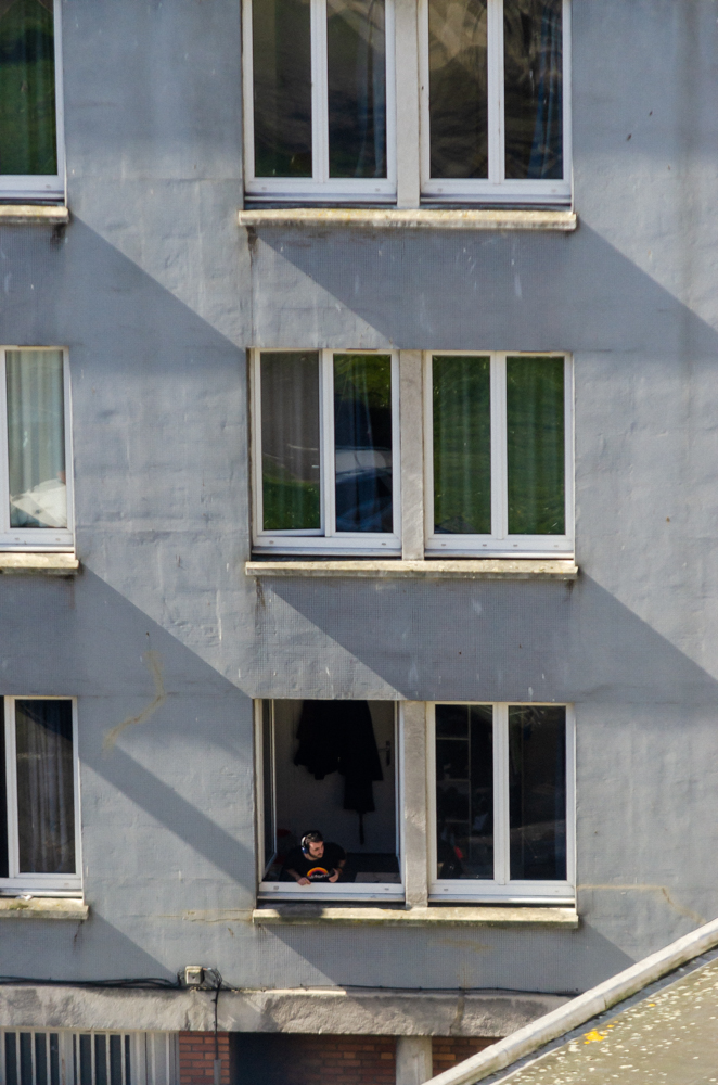 Photo d'un homme confiné regardant par la fenêtre