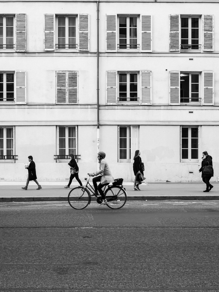 Photo de rue d'une femme en vélo à Paris