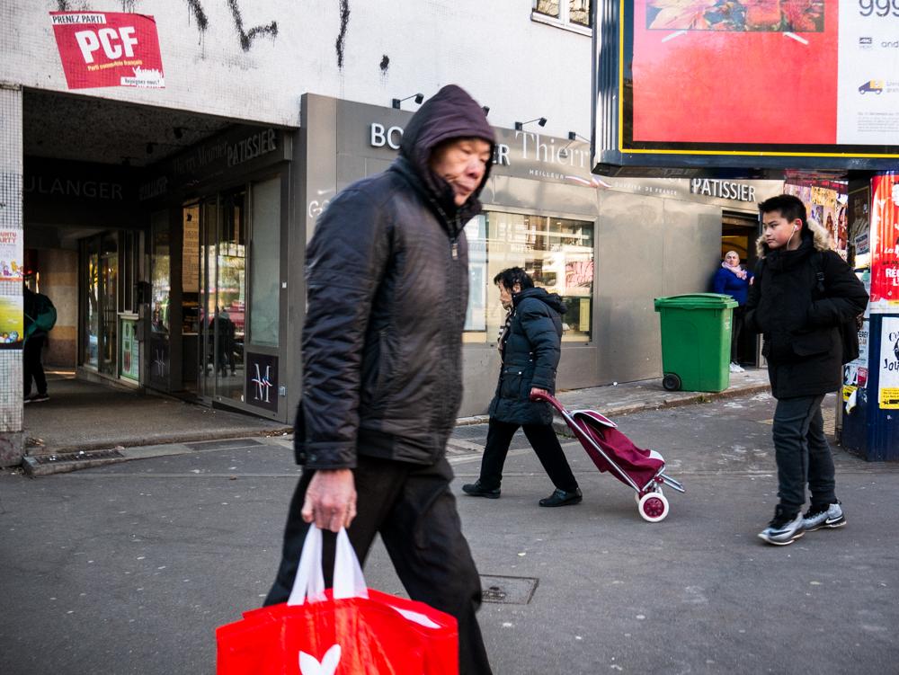 Plusieurs personnes de tous ages marchant dans la rue, il y a de nombreux rappels de rouges