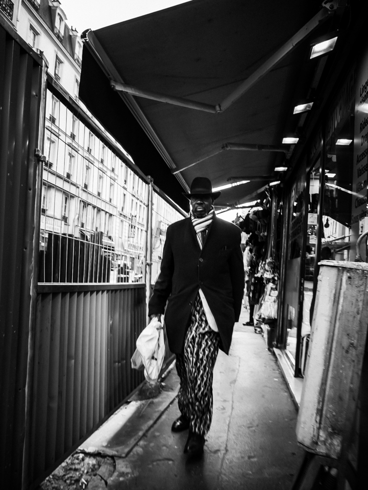 Homme avec un chapeau melon rentrant des courses à Paris